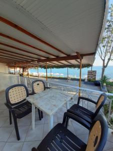 a table and chairs on a patio with the ocean at Paraga Rooms Pefkari in Pefkari