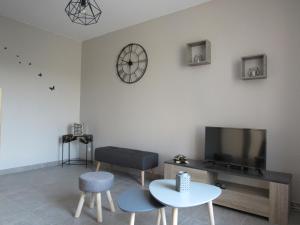 ein Wohnzimmer mit einem TV und einem Tisch in der Unterkunft Gite la Ressource O' Naturel in Bonningues-lès-Ardres