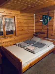 a large bed in a wooden room with at Domek letniskowy Grodek in Gródek Nad Dunajcem