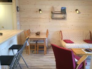 a dining room with a table and chairs and a couch at Le sirac in Orcières