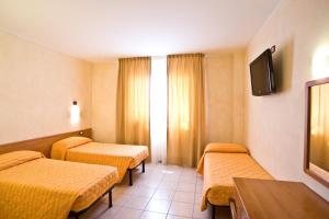 um quarto de hotel com duas camas e uma televisão em Hotel Colombo em Breda di Piave