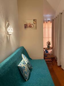 a living room with a green couch with pillows at Pedras D'el Rei - Vista Ria in Tavira +37 photos
