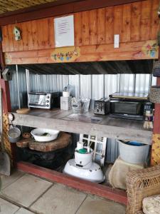 a kitchen with a counter with pots and a microwave at Hebergement Cerfs-Tifie fermette in Saint-Félix-d'Otis