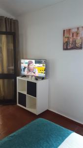 a tv sitting on a stand in a living room at Pedras D'el Rei - Vista Ria in Tavira
