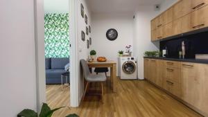 a kitchen with a table and a laundry room at Apartament Naturalny-Lake Apartments, osiedle Calamo Park-Olsztyn in Olsztyn