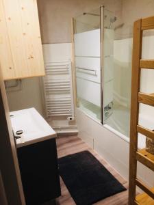 a small kitchen with a shower and a refrigerator at Le sirac in Orcières