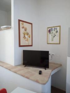 TV de pantalla plana sentada en una mesa en una habitación en Affittacamere degli Dei da Ico, en Monzuno
