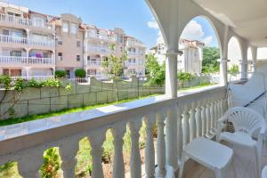 balkon z białymi krzesłami i budynek w obiekcie Your lovely summer home in Sunny Beach w Słonecznym Brzegu
