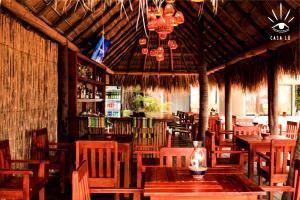 een restaurant met houten tafels en stoelen en een bar bij Casa Lu Hotel Boutique in Mazunte