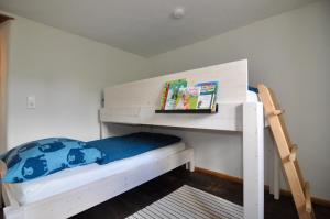 ein Schlafzimmer mit einem Etagenbett und einem Bücherregal in der Unterkunft Ferienhaus Baustert in Baustert