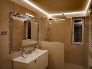 y baño con lavabo y espejo. en Fűzliget Mangó Terrace, en Balatonfűzfő