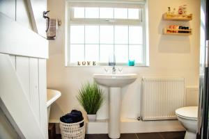 baño con lavabo y ventana en The Orchards, en Kendal