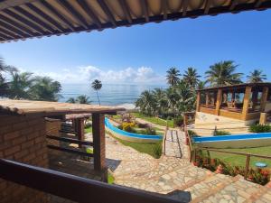 a view of the ocean from a resort with a boat at Pousada Enseada do Sol in Jacumã