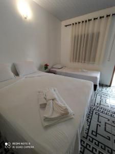 een slaapkamer met 2 bedden en handdoeken bij Chalé Marinas in Barreirinhas