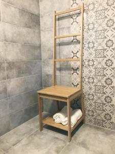 a wooden shelf in a bathroom with a shower at Grand Terasz in Tiszafüred