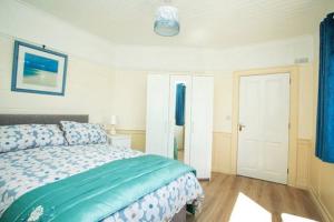 una camera da letto con un letto con un piumone blu di Cargagh Cottage a Annacloy
