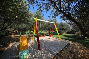 a playground with colorful swings in a park at Villa Cvita in Povljana