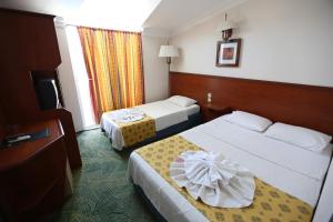 a hotel room with two beds and a television at Paradise Hotel in Kemer