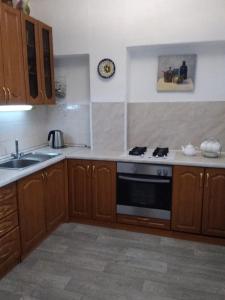 a kitchen with wooden cabinets and a stove top oven at Апартаменты Бутусовские in Yaroslavl