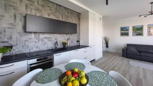 una cocina con una mesa con un bol de fruta. en Apartament Rodzinny - Lake Apartments, osiedle Calamo Park - Olsztyn, en Olsztyn