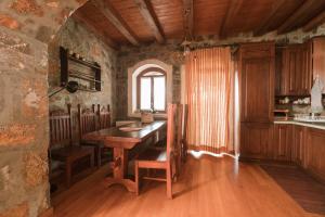 uma cozinha com uma mesa de madeira e uma janela em Rustic Stone Home, Milopotamos, Rethymno em Agrídhia