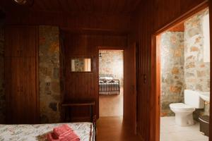 a bedroom with a bed and a sink and a toilet at Rustic Stone Home, Milopotamos, Rethymno in Agrídhia