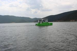 un barco verde en medio de un lago en Kivotos Epavlis, en Prespes