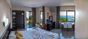 a bedroom with a bed and a desk with a view at Hotel Melike in Kusadası