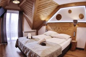 a bedroom with a large bed in a room with wooden ceilings at Willa Palider in Zakopane