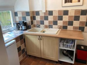 une cuisine avec un évier et un plan de travail dans l'établissement La Vieille Crêperie de Mangouëro, à Cléguérec 6 autres photos