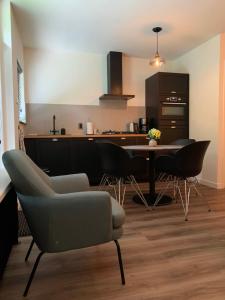 uma cozinha com mesa e cadeiras num quarto em Bonte Specht: tot rust komen in de natuur! em Otterlo