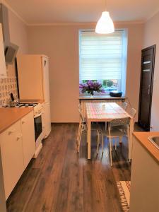 a kitchen with a table and a refrigerator and a window at Center Rooms in Jarosław