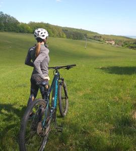 a woman riding a bike in a field at Cseri Kastélyszálló in Tótvázsony