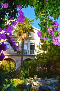 un edificio con flores púrpuras en un jardín en Roso, en Gradac