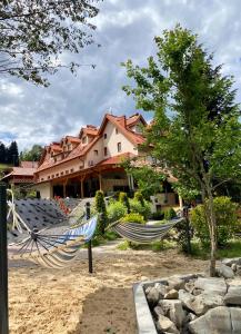two hammocks in the sand in front of a house at Hotel Fero Lux in Korbielów