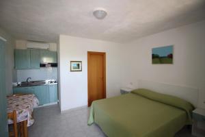 um quarto com uma cama verde e uma cozinha em La Dimora dei Pescatori em Vieste