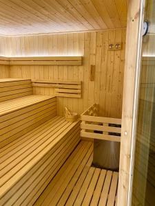 a wooden sauna with a bench and a tub at Hotel Fero Lux in Korbielów