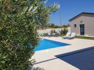 einen Pool in einem Garten mit Stühlen und einem Haus in der Unterkunft Small house Tia with private pool in Pula
