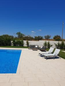 a swimming pool with lounge chairs next to a swimming pool at Small house Tia with private pool in Pula