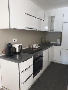 a kitchen with white cabinets and a black appliance at Small house Tia with private pool in Pula