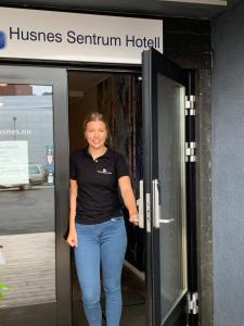 a woman standing in the doorway of a hotel at Husnes Sentrum Hotell in Husnes