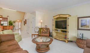Una sala de estar con un sofá y un televisor. en Comfortable Home on Golf Course in NSB - 1929T, en New Smyrna Beach