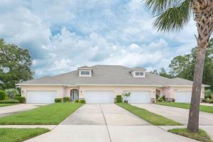 una casa blanca con una palmera delante en Comfortable Home on Golf Course in NSB - 1929T, en New Smyrna Beach