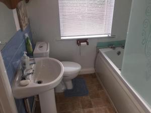 a bathroom with a sink and a toilet and a tub at Worcester Town Home & Garden in Hindlip +18 photos