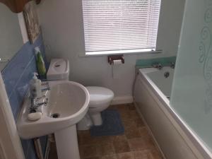 a bathroom with a sink and a toilet and a tub at Worcester Town Home & Garden in Hindlip