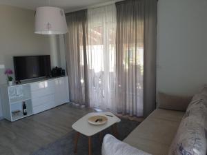 ein Wohnzimmer mit einem Sofa und einem TV in der Unterkunft Small house Tia with private pool in Pula