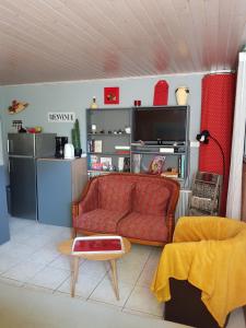a living room with a red couch and a kitchen at Gîte Mercues in Mercuès