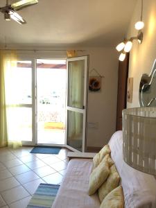 - une chambre avec un lit et une porte coulissante en verre dans l'établissement Traumblick, à Valledoria
