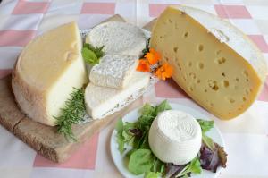 um prato de queijo e legumes numa mesa em Agriturismo dell'Altopiano em Serle