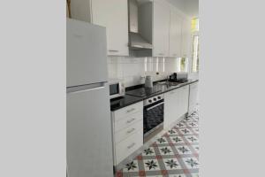 een keuken met witte apparatuur en een tegelvloer bij Casa do Largo Sardinha - Very central apartment in Lissabon